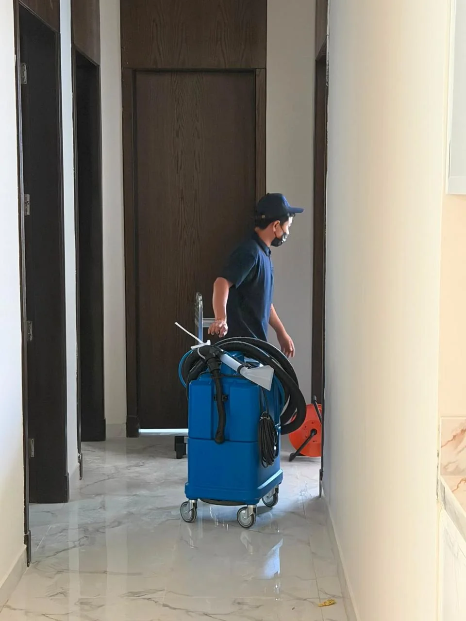 أحد أفراد فريق إكسا كلين ينقل جهاز التنظيف داخل المنزل